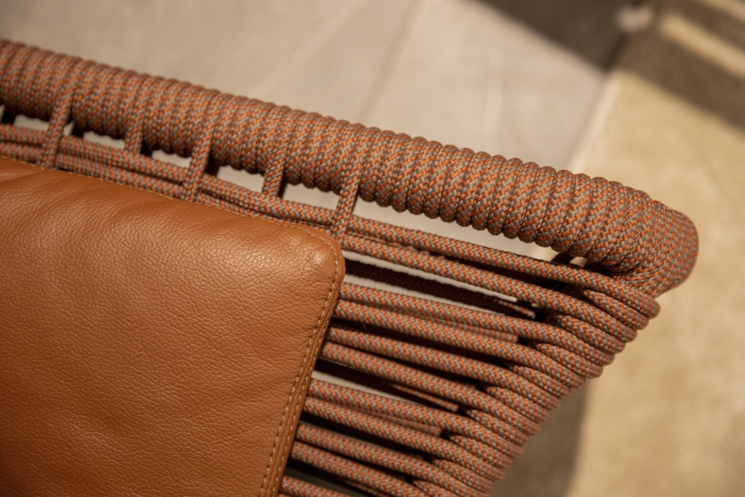Rolfing woven rattan and leather chair detail, close-up of armrest and intricate woven design, modern premium furniture from Saloni Furniture, perfect for contemporary interior decor, emphasizing craftsmanship and quality materials.