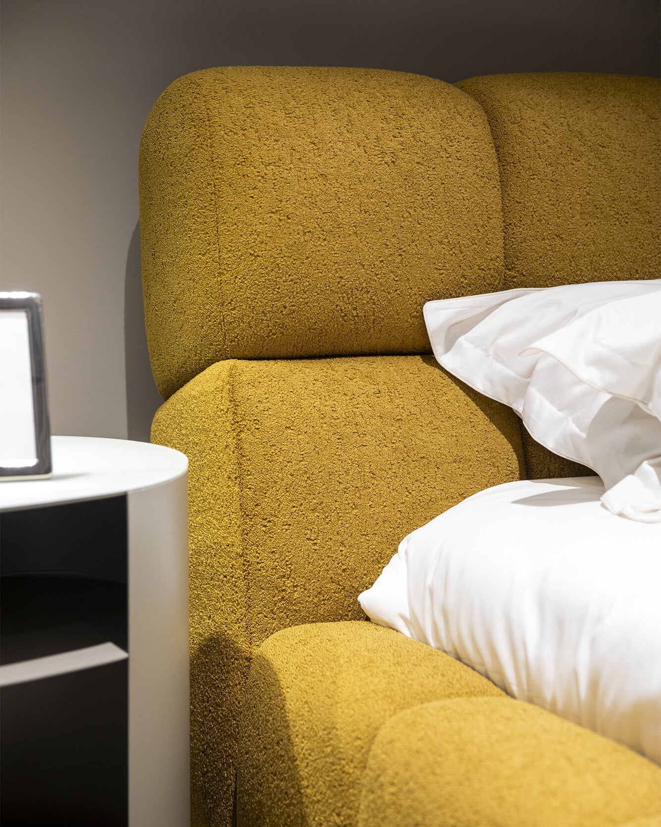 Luxurious mustard yellow upholstered headboard with textured fabric, contemporary bedroom design, stylish and comfortable, perfect for modern home decor.