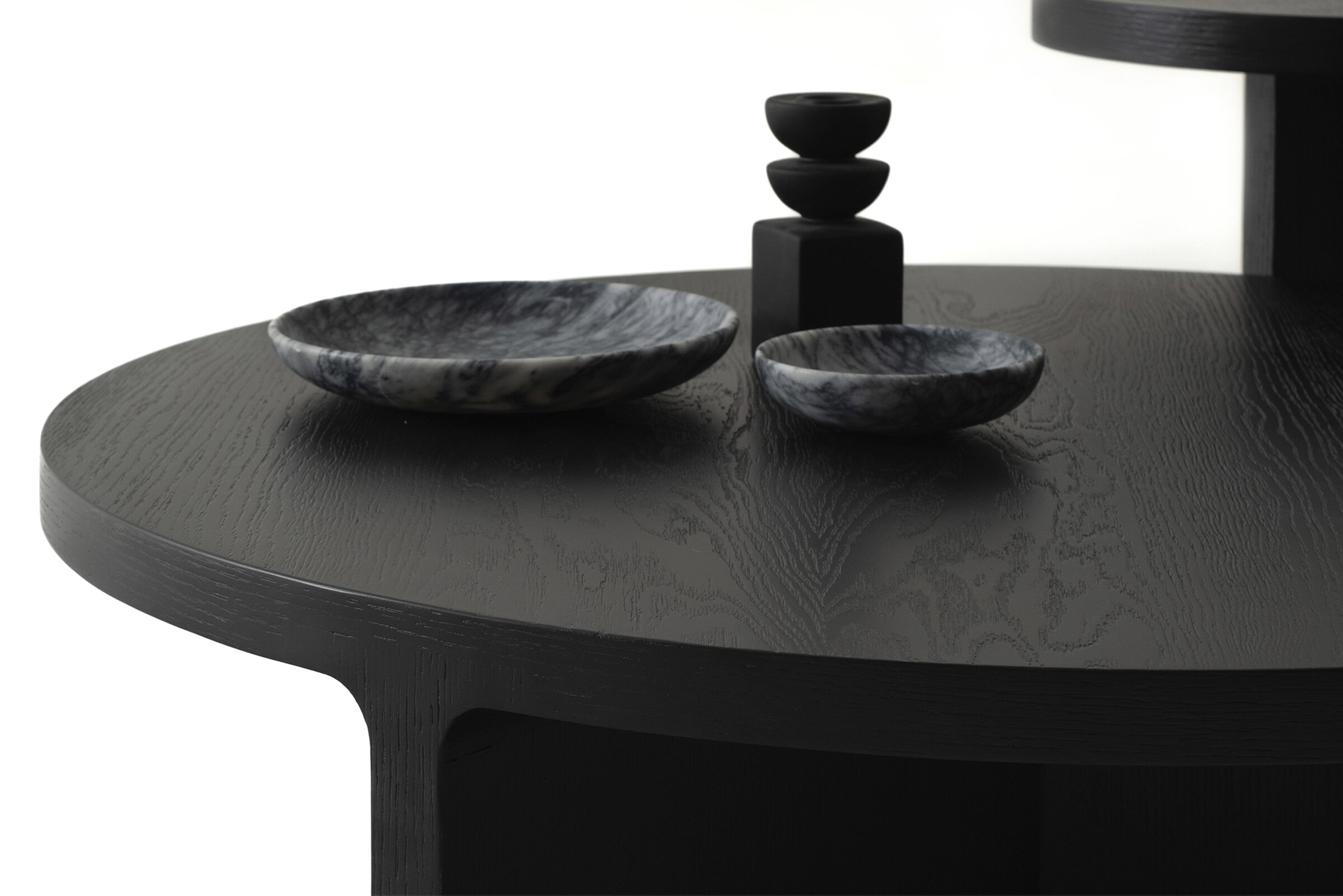 Black wooden coffee table with marble bowls and decorative items from Saloni Furniture.