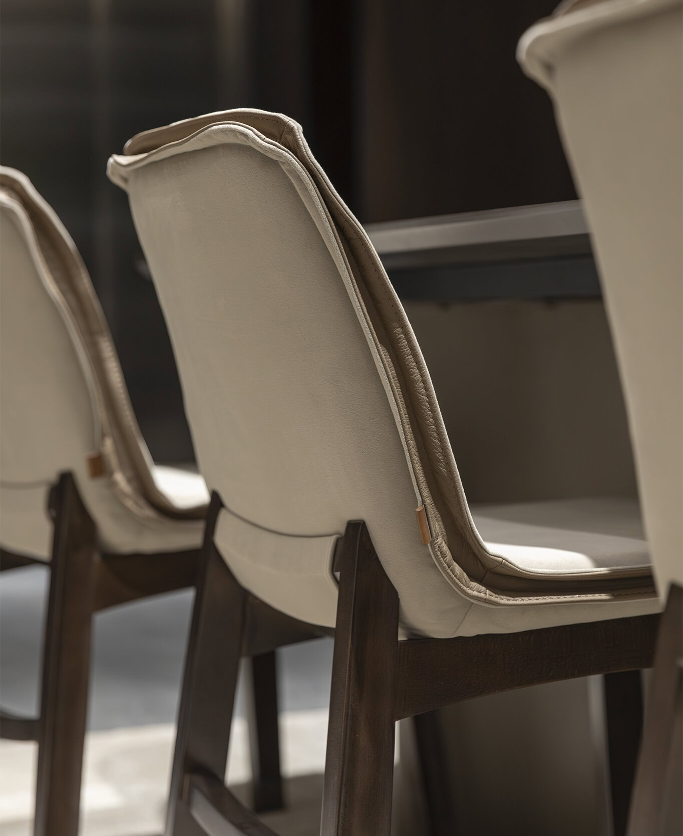 High-quality beige upholstered dining chairs with dark wood legs, modern and stylish design, perfect for contemporary home dining rooms, from Saloni Furniture.