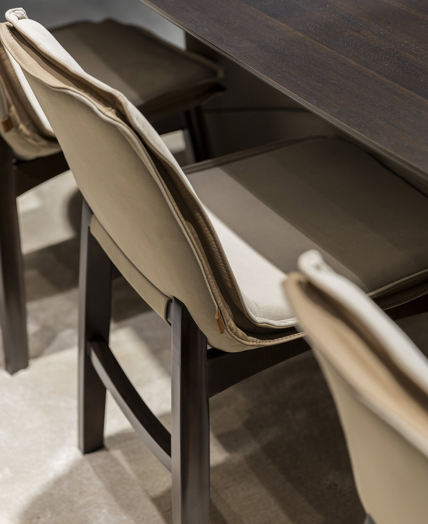 Stylish beige and brown upholstered dining chairs with black wooden legs, perfect for modern home or restaurant interiors, combining comfort and contemporary design.