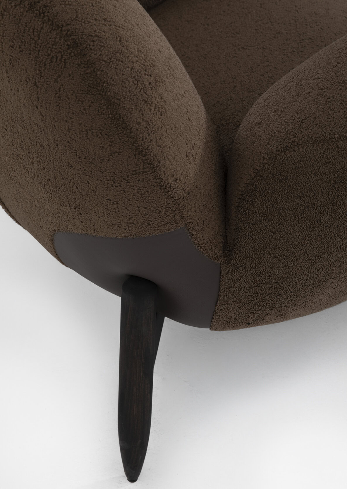 Soft brown upholstered armchair with wooden leg for modern living room decor.