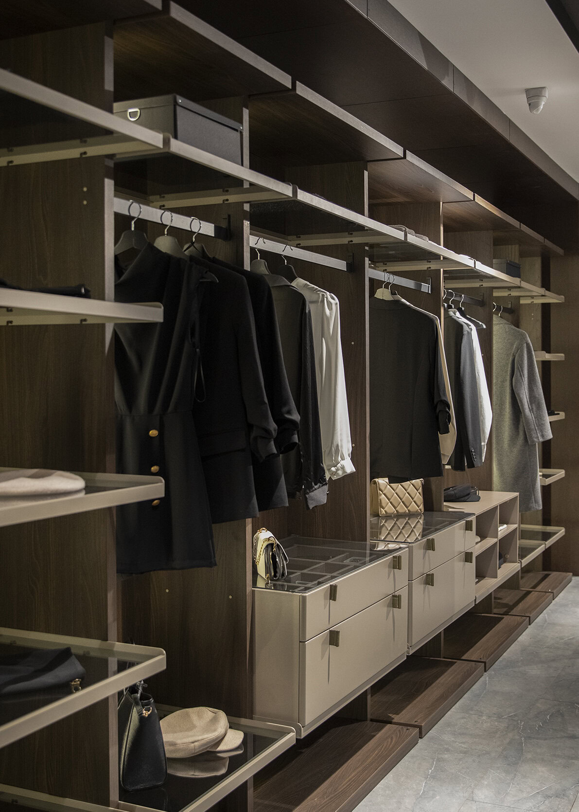 Elegant modern wardrobe closet with dark wood finish, white shelving, and hanging space for clothes, accessories, and shoes, ideal for stylish home storage solutions.
