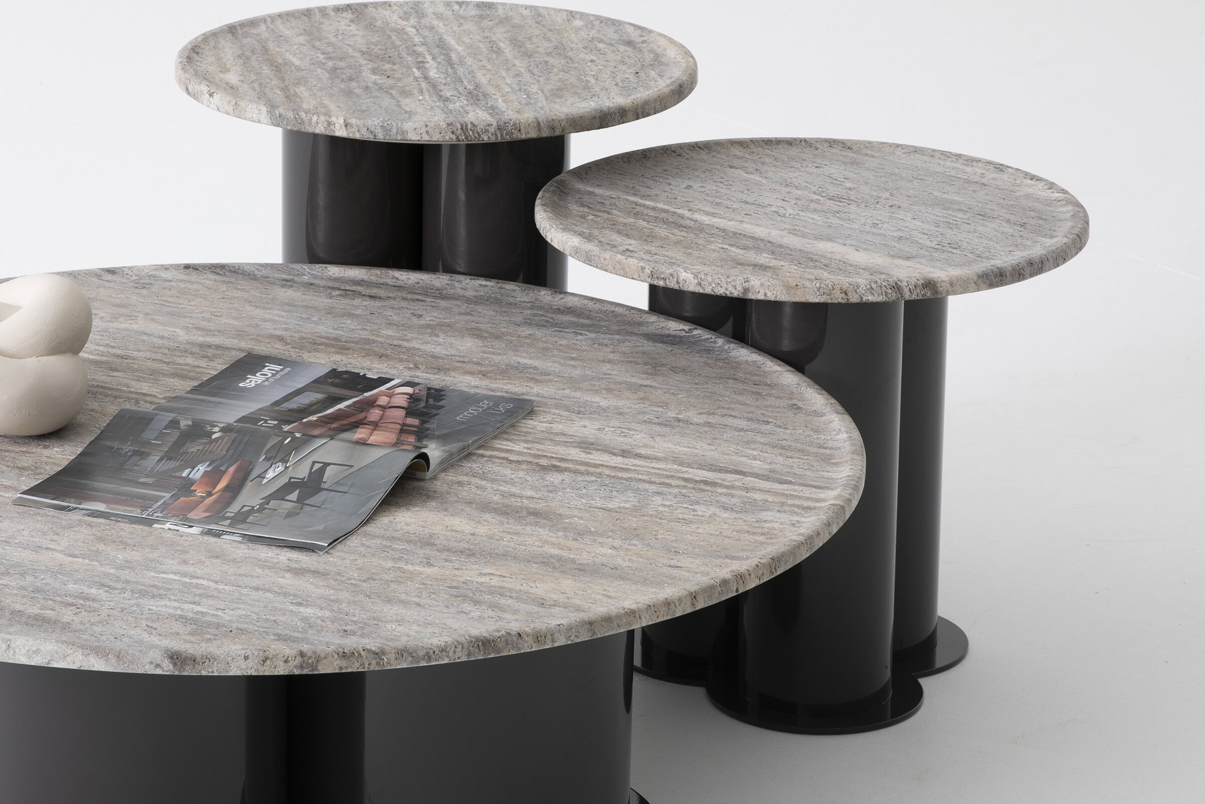 Smooth beige and grey marble coffee tables with black cylindrical bases, modern and stylish, ideal for contemporary living room decor, part of Saloni Furniture collection.